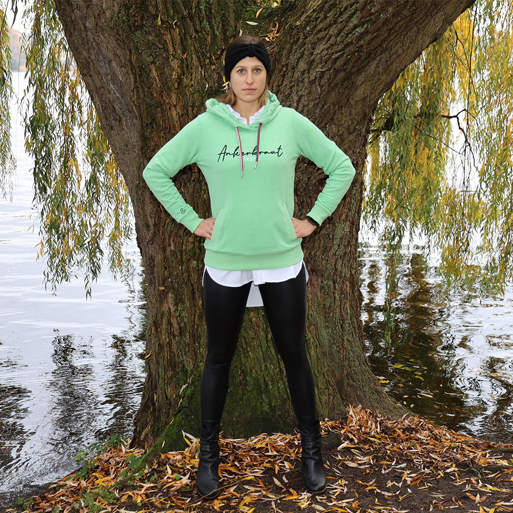 Weibliches Model mit ANKERBRAUT Hoodie in Absinth Green